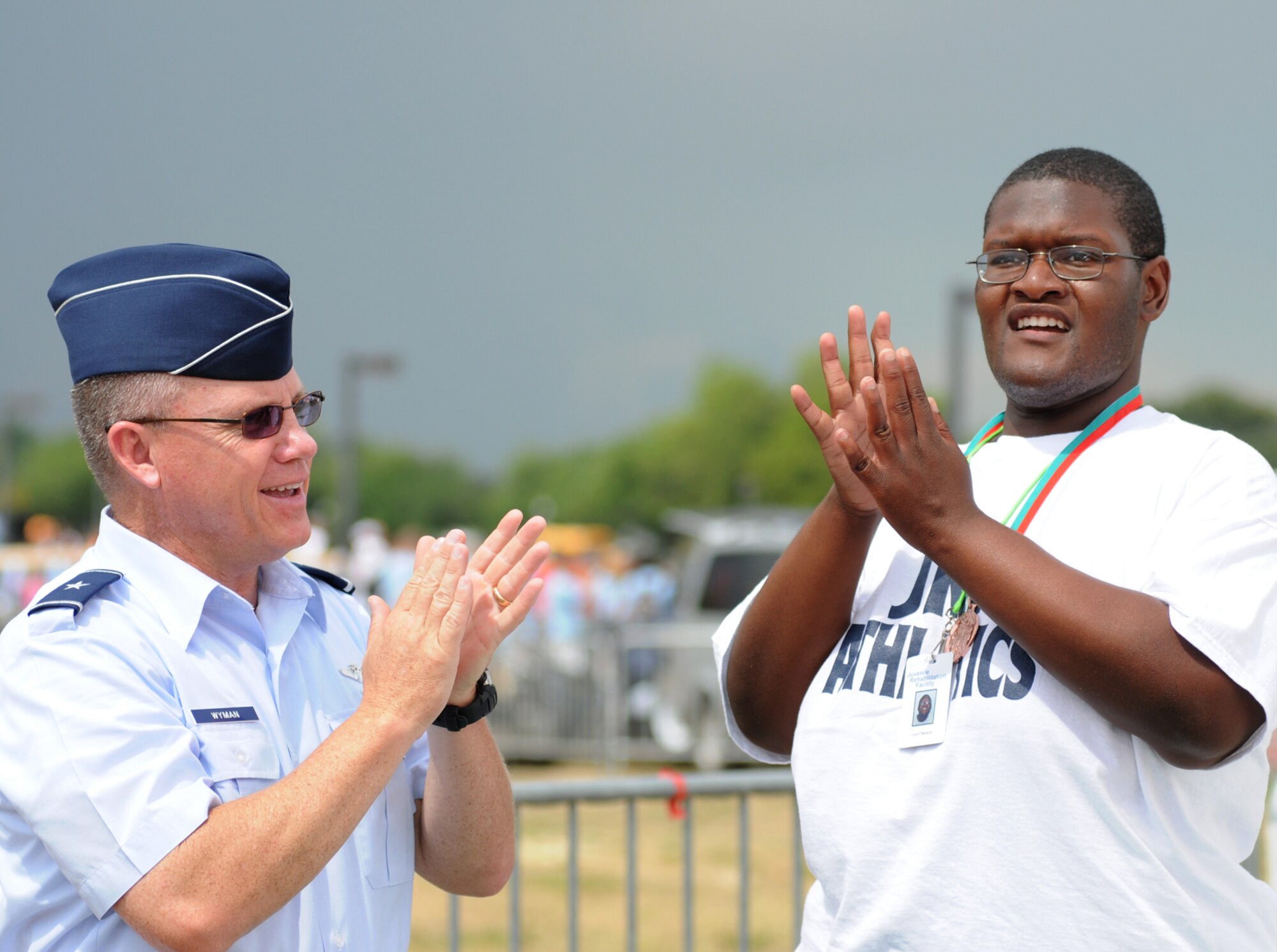 Saturday’s stormy skies don’t dampen the spirits of Area 2 athlete Leon Nelson after he was awarded a bronze medal in the 50-meter assisted walk by Brig. Gen. Daniel Wyman, 81st Medical Group commander, during the track and field events.  (U.S. Air Force photo by Kemberly Groue)