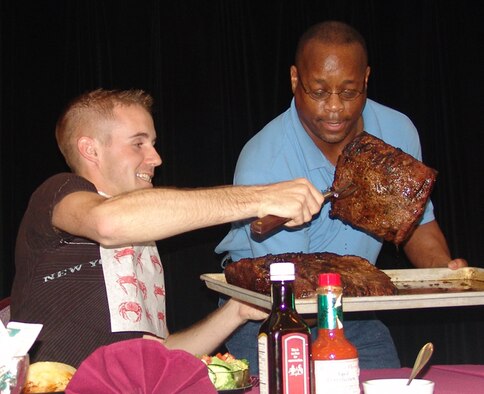 WHITEMAN AIR FORCE BASE, Mo. - Airman 1st Class Carlin Leslie, 509th Bomb Wing, attempts to choose the smallest looking steak. in addition to having to finish the 96 oz. steak, participants also had to finish off the rest of the meal that included a salad, baked potato and green beans. (U.S. Air Force photo/Donna Barker)