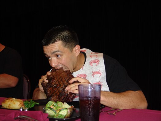 WHITEMAN AIR FORCE BASE, Mo. - Staff Sgt. Henry Lopez, 509th Force Support Squadron, uses a "hands-on" strategy to devour his meal. In addition to having to finish the 96 oz. steak, participants also had to finish off the rest of the meal that included a salad, baked potato and green beans. (U.S. Air Force photo/Donna Barker)