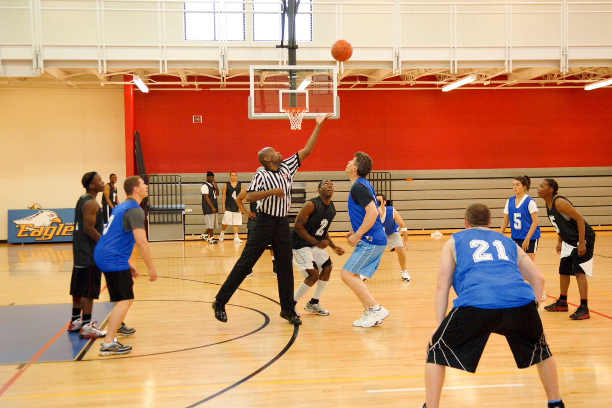HANSCOM AIR FORCE BASE, Mass. –Russell Jackson, 66th Services Squadron, tips off the Hanscom Olympics basketball competition between the Electronic Systems Center Staff (blue uniforms) and the U.S. Army team. Hanscom’s Olympic games will close on May 21, with a morning kickball competition, followed by an awards ceremony at noon and a base picnic to immediately follow. Teams from the base’s five wings, Air Force Research Laboratory, ESC Staff and joint service personnel have been vying for Olympic gold in a number of athletic events. (U.S. Air Force photo by Rick Berry)