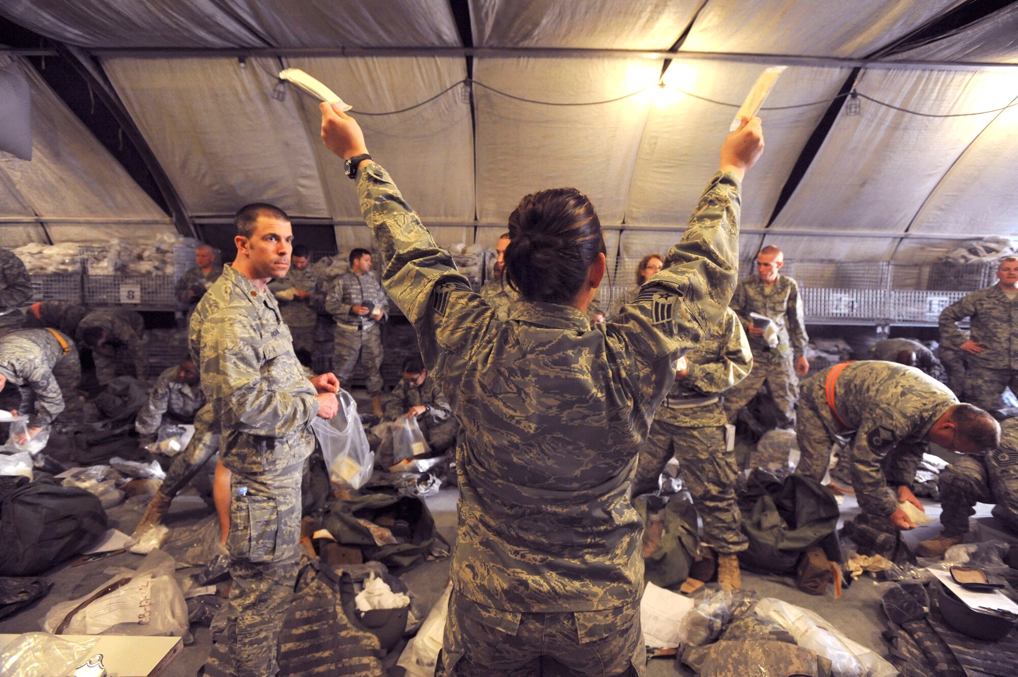 Senior Airman Kalynn Helton, a mobility specialist with the 379th Expeditionary Logistic Readiness Squadron, shows transient Air Force personnel the items they should have in their C-bags here, May 19, 2009, in an undisclosed location in Southwest Asia.  Airman Helton and fellow mobility specialists at the expeditionary theater distribution center ensure all transient and forward deploying Air Force personnel are properly equipped prior to reaching their final destination in the U.S. Central Command's area of responsibility. Airman Helton is native to Gilson, Ill. and is deployed from Illinois Air National Guard in support of Operations Iraqi and Enduring Freedom and Combined Joint Task Force - Horn of Africa.  (U.S. Air Force Photo by Staff Sgt. Joshua Garcia/released)