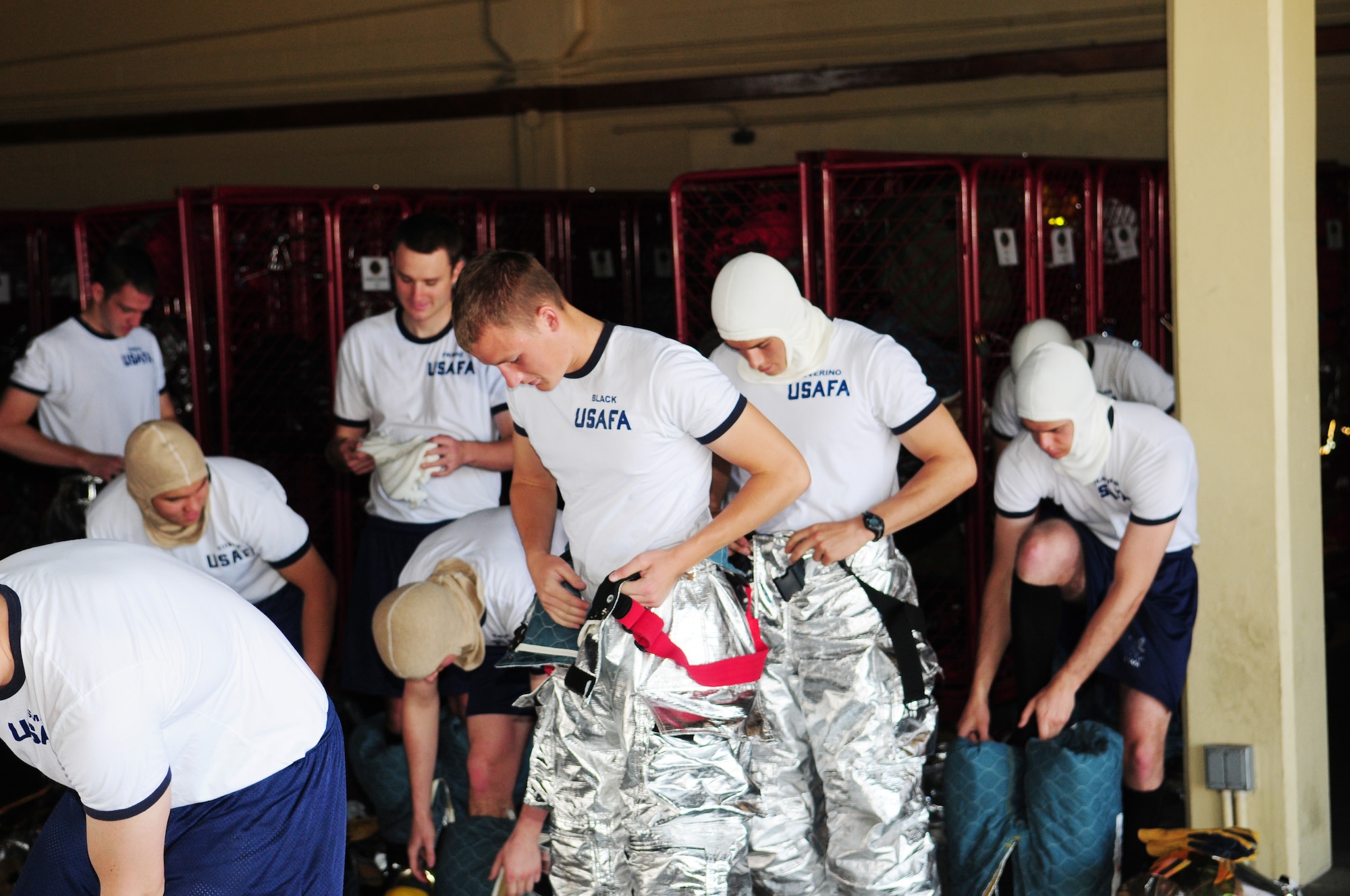 ANDERSEN AIR FORCE BASE, Guam -- United States Air Force Academy cadets climb into their "firefighter bunkers" prior to performing a firefighter intensive physical training course at the fire house here May 19. The term, ‘bunkers,’ refers to the fire retardant personal protective equipment worn by firefighters.  The cadets visited the fire house to observe enlisted personnel in action and see a display of enlisted leadership. (U.S. Air Force photo by Tech. Sgt. Michael Boquette)