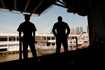 Lance Cpl. Andrew Collins, a explosive ordnance disposal technician from San Antonio, Texas, and Petty Officers 3rd Class Michael Georgtadis, an aviation ordnanceman from Mt. Holly, N.J., look over the deck of the USS Iwo Jima at Manhattan, May 20. The USS Iwo Jima is docked in Pier 88 as part of Fleet Week 2009. "It's great being home, and I'm looking forward to catching some baseball games," said Georgtadis, who recently returned from a deployment to Afghanistan.