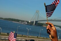NEW YORK CITY -- On-lookers wave flags as Navy ships pass by Fort Hamilton, N.Y. The Army base gave the Parade of Sail ships a 17-gun salute, May 20. The Navy and Marine Corps are in New York City from May 20-27 for Fleet Week, a week long display of military equipment and personnel. (Official Marine Corps photo by Sgt. Randall A. Clinton)