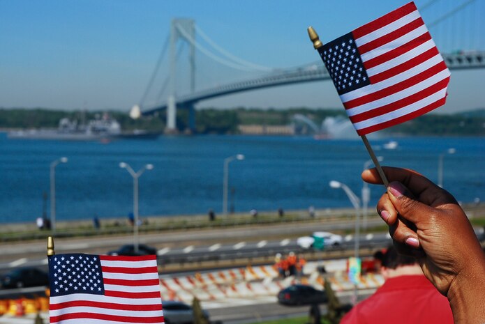 NEW YORK CITY -- On-lookers wave flags as Navy ships pass by Fort Hamilton, N.Y. The Army base gave the Parade of Sail ships a 17-gun salute, May 20. The Navy and Marine Corps are in New York City from May 20-27 for Fleet Week, a week long display of military equipment and personnel. (Official Marine Corps photo by Sgt. Randall A. Clinton)