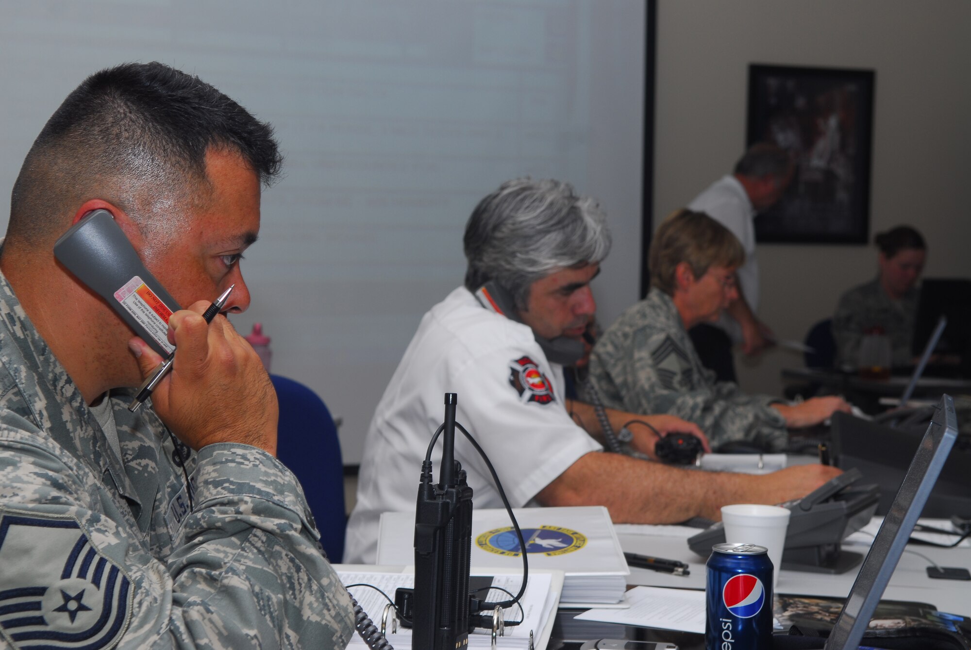 BUCKLEY AIR FORCE BASE, Colo. -- Members of Buckley's Emergency Operations Center relay information to their various counterparts across the base in support of the Vigilant Front Range Exercise here May 15. The EOC acts as the hub between the Installation Control Center and the on-scene commander during major accident response incidents.  The exercise involved federal, state and local agencies working with base agencies to test plans and build understanding, trust and relationships essential in the fast-paced environment of major disasters. (U.S. Air Force photo by Staff Sgt. Anika Williams)