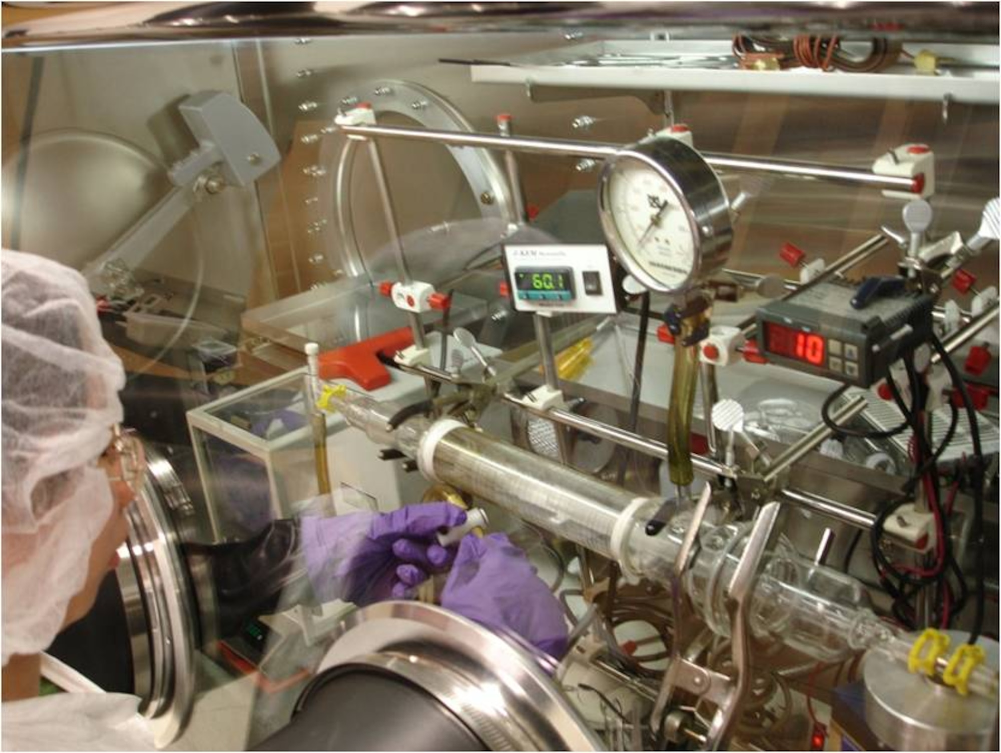 Student Chia-Yi Chen sets up a custom built Chemical Vapor Deposition reactor inside a Vacuum Atmospheres' 'glove box' that maintains an environment that excludes oxygen and moisture. (Credit: Dr. Arthur Epstein, Ohio State University)