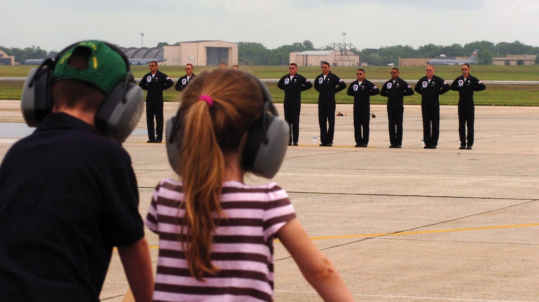A couple of young fans wearing ear protection wait for autographs from the U.S. Air Force Thunderbirds pilots, as the groundcrew are introduced on the flightline, prior the the fleet of F-16 aircraft landing during the JSOH May 15. (U.S. Air Force photo/ Bobby Jones)