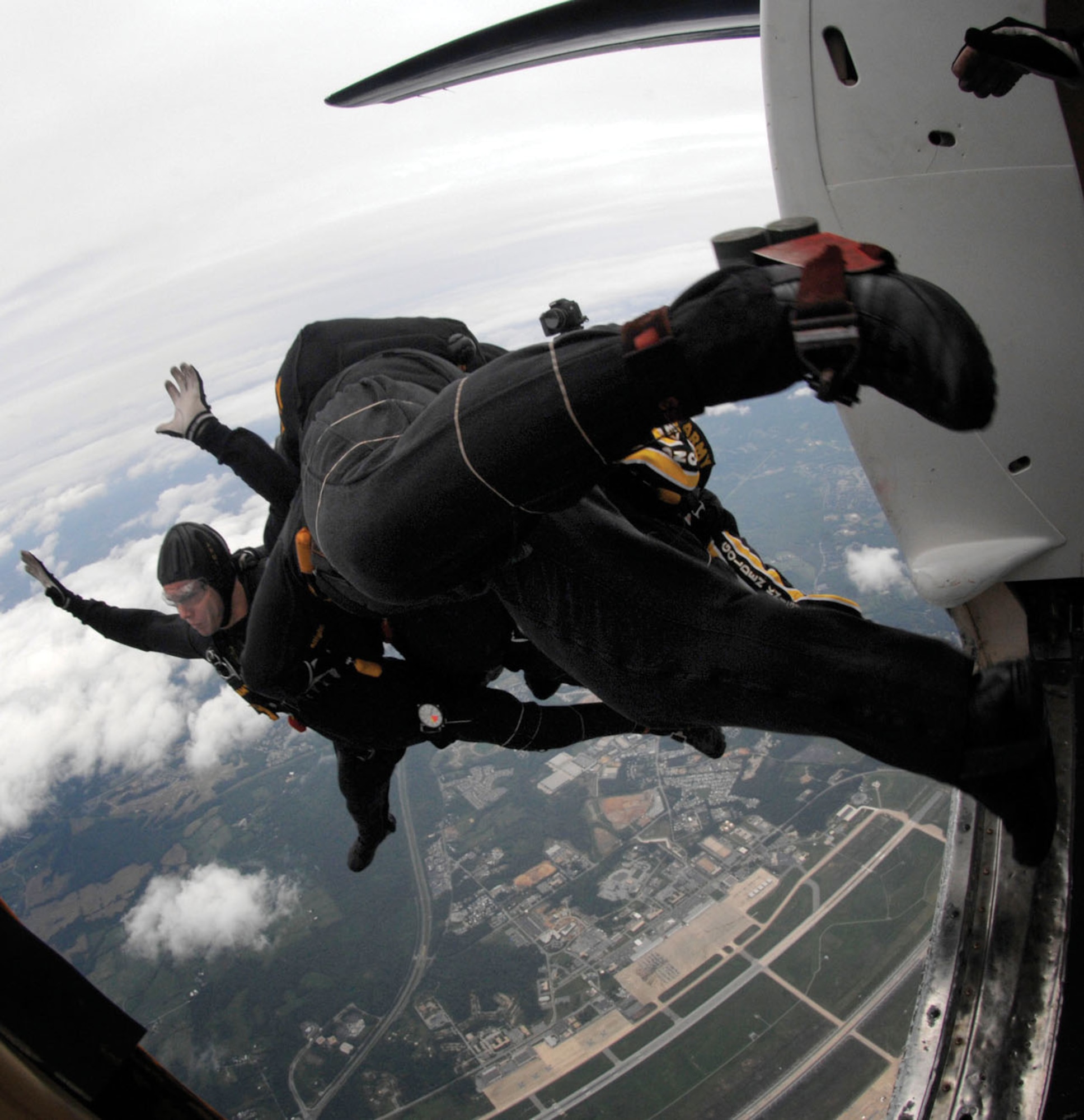 Members of the Army Golden Knights “Black” demonstration jump team show their skydiving skills during the JSOH May 17. Seven Golden Knights members hooked together in a formation followed by their cameraman, who jumps separately to photograph the formation in the air. (U.S. Air Force photo/ Airman 1st Class Melissa Rodrigues)