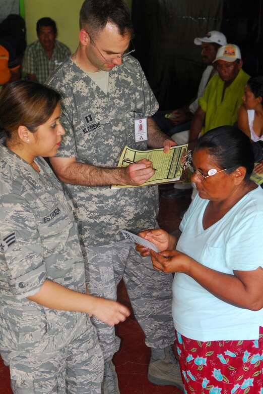 ALAJUELA, Costa Rica -- Senior Airman Maricella Estrada, a 30th Medical Operations Squadron flight medicine technician, helps translate for a Spanish-speaking local resident and Capt. Adam Klemens, a 30th MDOS technician optometrist, here May 20. A team of medical specialists from Vandenberg is contributing to a humanitarian effort with local Costa Rican physicians here. (U.S. Air Force photo/Airman 1st Class Steve Bauer)