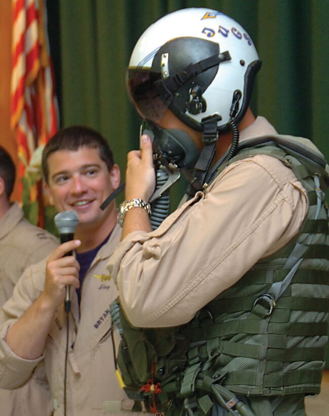 Navy Lt. Bryan Pinckney, weapons systems officer, describes how an oxygen mask is used by Lt. Justin Halligan, pilot, during a show-and-tell demonstration of equipment used during flight maneuvers. (U.S. Air Force photo/ Bobby Jones)