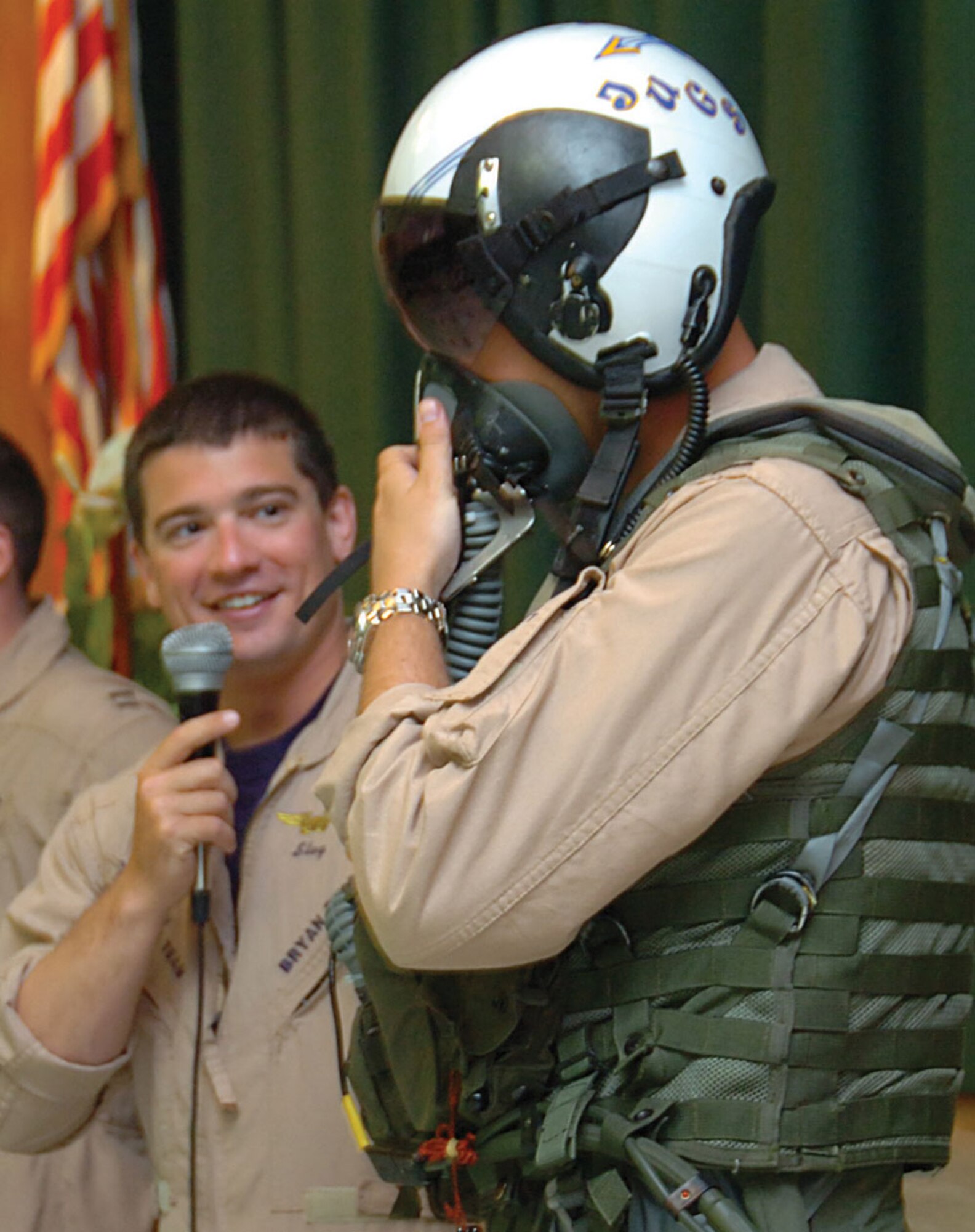 Navy Lt. Bryan Pinckney, weapons systems officer, describes how an oxygen mask is used by Lt. Justin Halligan, pilot, during a show-and-tell demonstration of equipment used during flight maneuvers. (U.S. Air Force photo/ Bobby Jones)