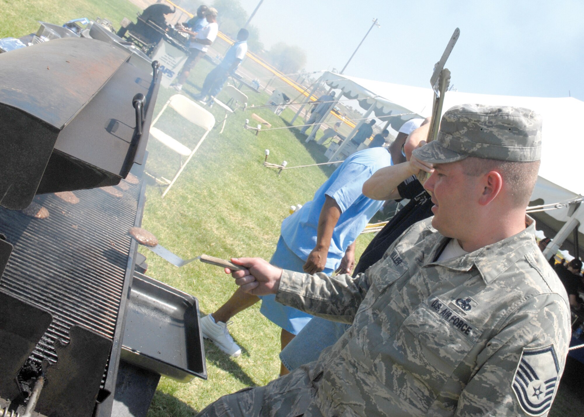 Master Sgt. Eric Miller, 56th Aircraft Maintenance Squadron, grills burgers at the base picnic at Luke Air Force Base May 15. (U.S. Air Force photo/ Airman 1st Class Sandra Welch)