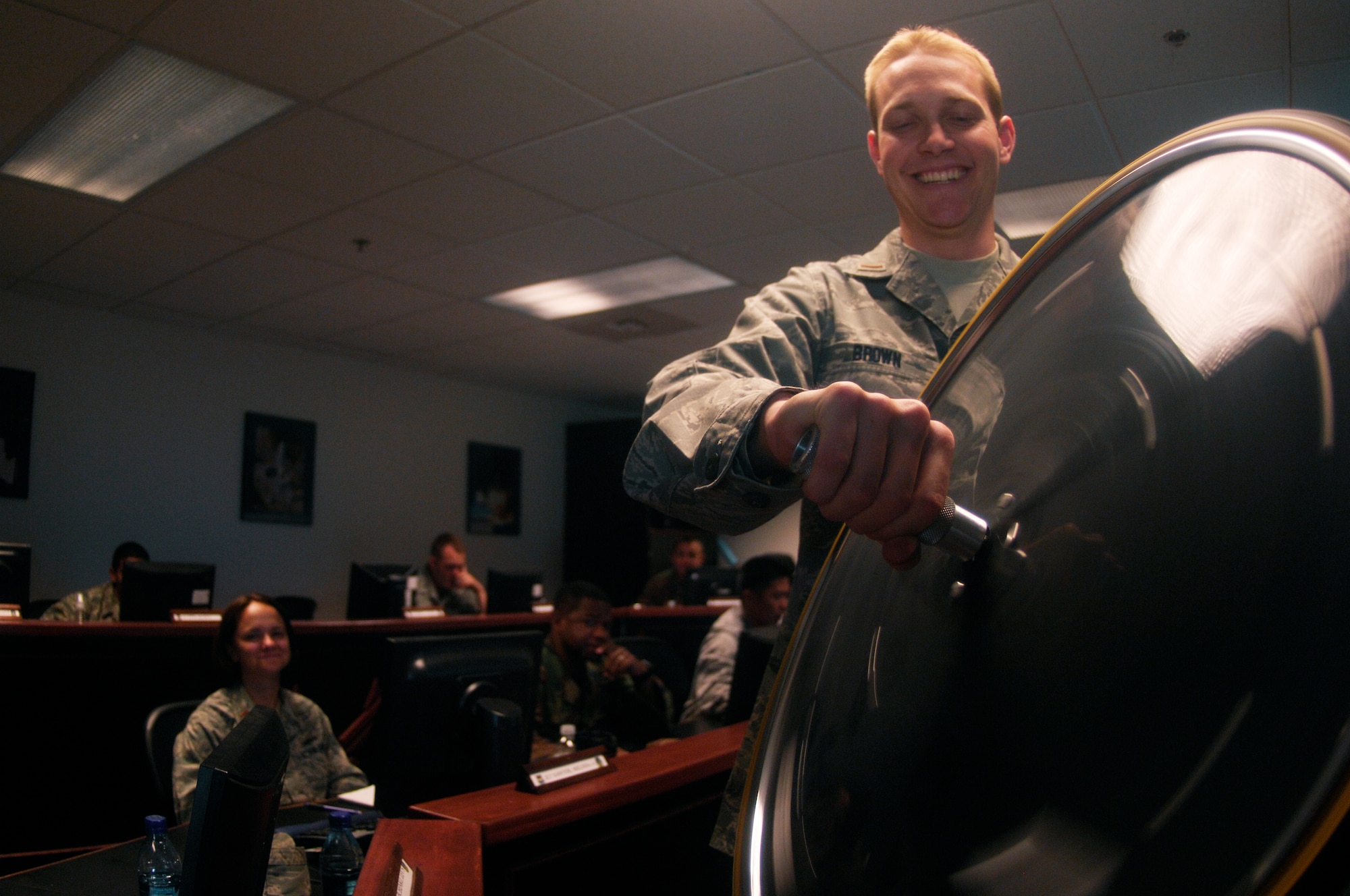 VANDENBERG AIR FORCE BASE, Calif. -- Learning the physics of a satellite, 2nd Lt. Adam Brown, a 392nd Training Squadron student, demonstrates how an attitude control system actuator for a satellite works for his Space 100 classmates here May 19. By standing on a rotating pedestal and holding a spinning wheel apparatus straight out in front of them, students are able to gain a fun understanding of how they make a satellite move by tilting the wheel either left or right. (U.S. Air Force photo/Senior Airman Matthew Plew)