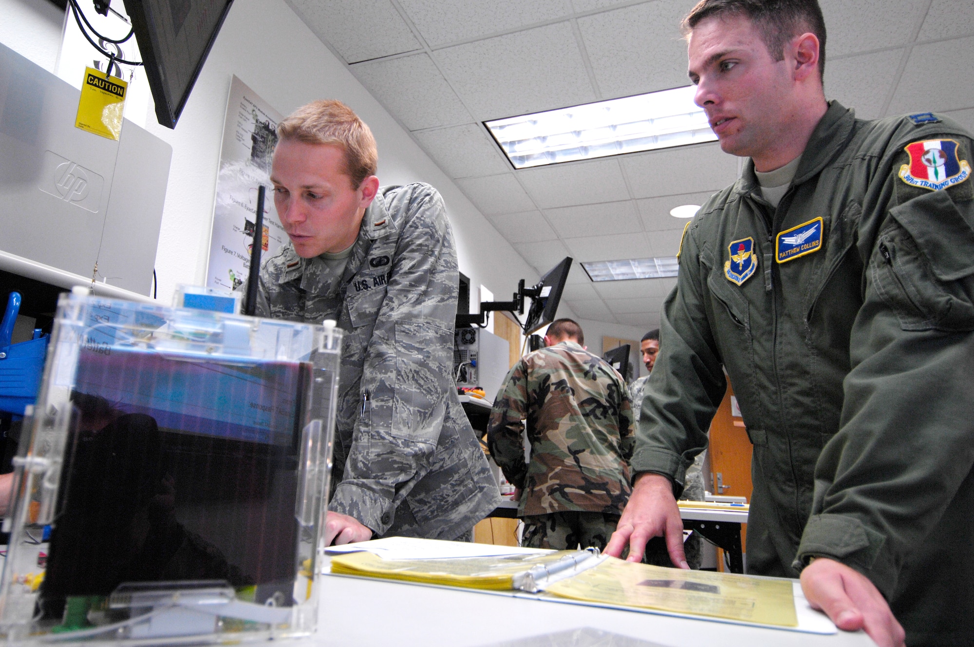 VANDENBERG AIR FORCE BASE, Calif. -- Space 100 instructor Capt. Matthew Collins provides guidance to 2nd Lt. Adam Brown during an EyasSat laboratory exercise here May 19. The EyasSat module is a major satellite subsystem designed to give students the hands-on experience they need to conduct successful satellite space operations for the Air Force. Captain Collins and Lieutenant Brown are both assigned to the 392nd Training Squadron. (U.S. Air Force photo/Senior Airman Matthew Plew)