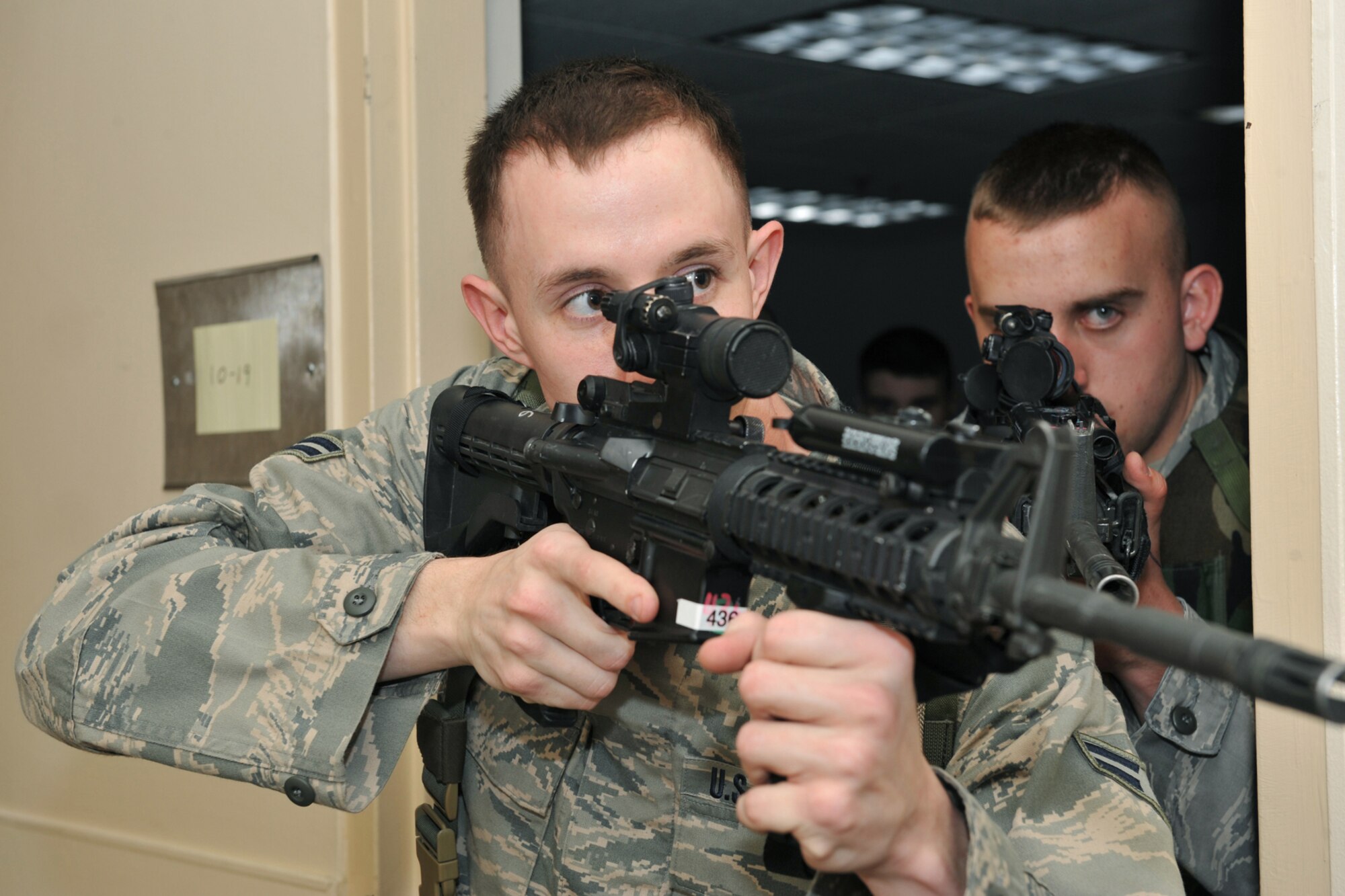 OFFUTT AIR FORCE BASE, Neb. -- Airman 1st Class Anthony Villmow and Airman 1st Class Benjamin Hoffman, both from the 55th Security Forces Squadron, conduct a search during a critical incident exercise inside the Martin Bomber Building here May 13. Joint training exercises such as this are common to ensure continuity between Offutt and local community first responders during a crisis situation.  U.S. Air Force Photo By Charles Haymond