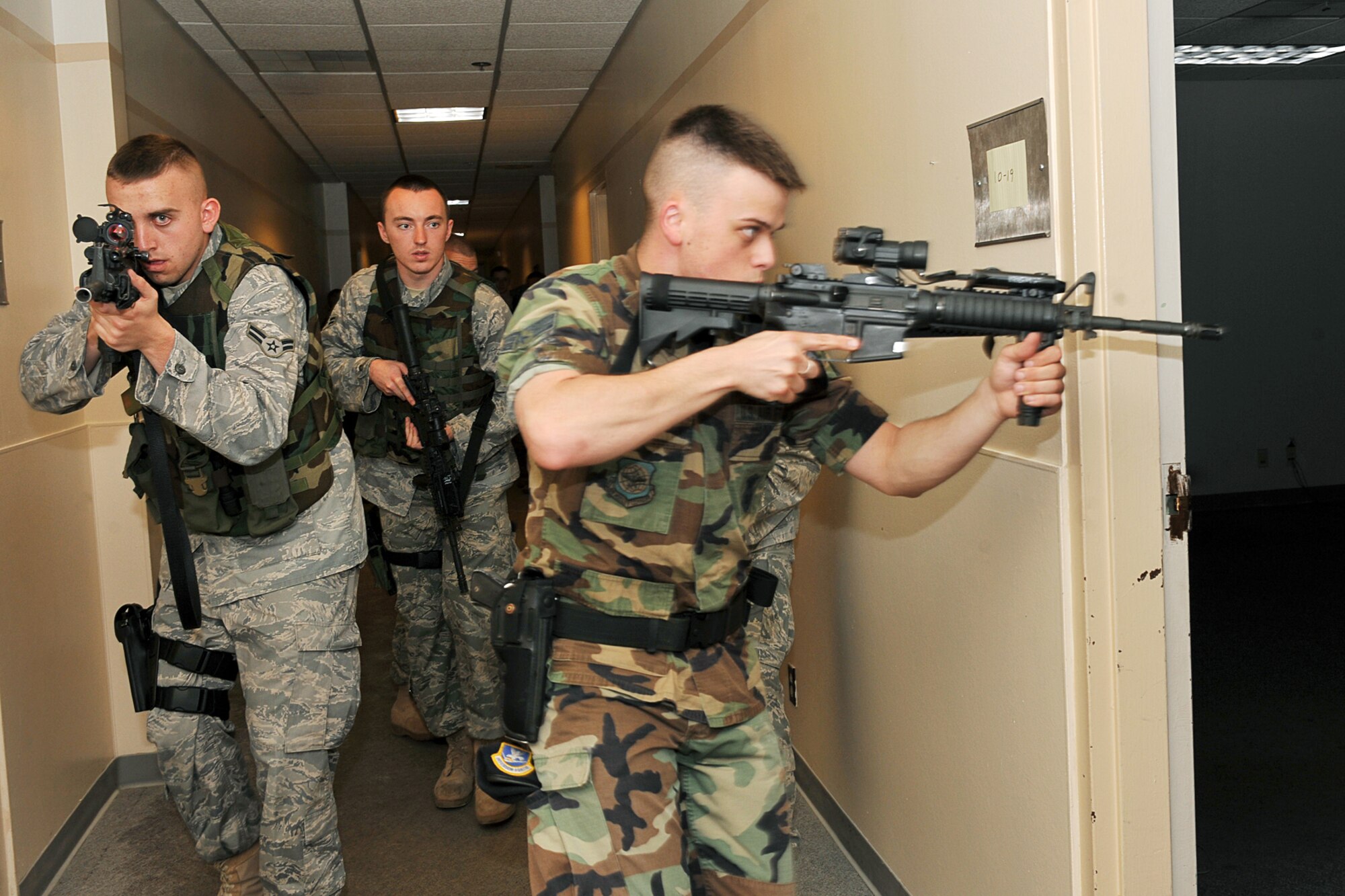 OFFUTT AIR FORCE BASE, Neb. -- Airman 1st Class Benjamin Hoffman, Airman 1st Class Jason Rowland and Senior Airman Sean Miller, all from the 55th Security Forces Squadron, enter a room during a critical incident response exercise inside the Martin Bomber Building here May 13. Joint training exercises such as this are common to ensure continuity between Offutt and local community first responders during a crisis situation.  U.S. Air Force Photo By Charles Haymond.