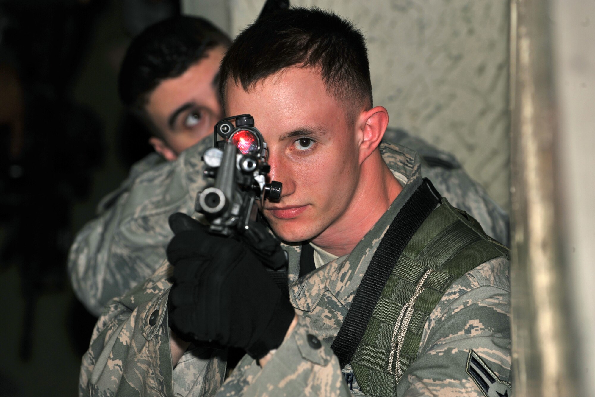 OFFUTT AIR FORCE BASE, Neb. -- Airman 1st Class Anthony Villmow and Senior Airman Michael Linke, both from the 55th Security Forces Squadron, aim their weapons during a simulated response to a critical incident exercise inside the Martin Bomber Building here May 13. Joint training exercises such as this are common to ensure continuity between Offutt and local community first responders during a crisis situation. U.S. Air Force Photo By Charles Haymond.