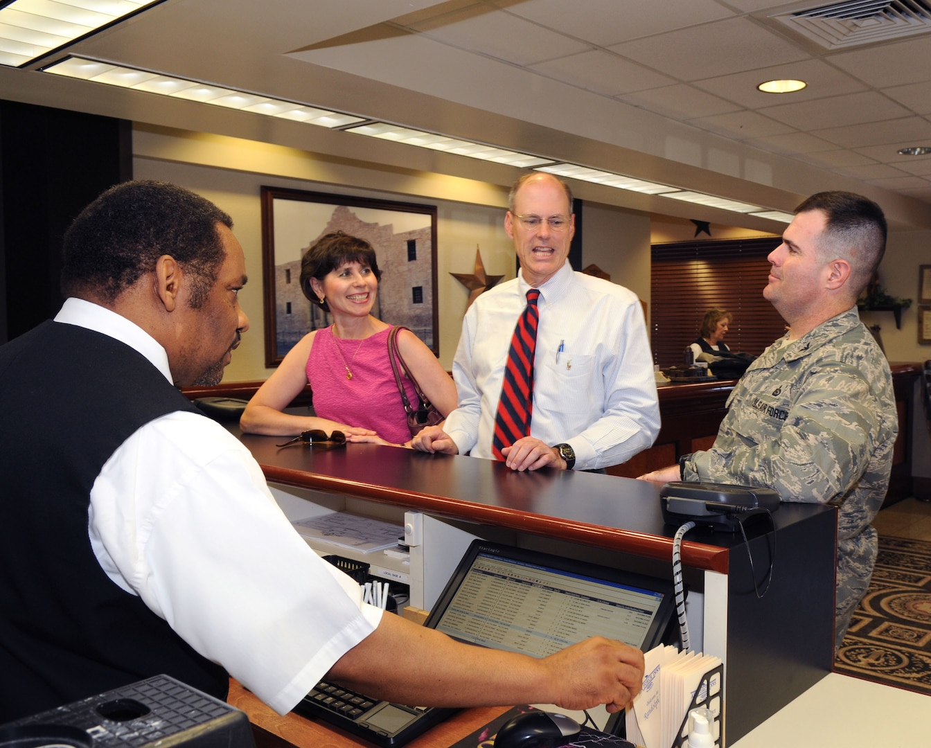 Samuel Brightman, Randolph Inn guest services representative, helps Mr. and Mrs. Jon Davis (center) of San Angelo, Texas, and Col. Scott Bethel, Air Education and Training Command, at the front desk of the Randolph Air Force Base, Texas, lodging facility. The Randolph Inn lodging team was awarded the AETC 2009 Air Force Innkeeper Award recently and will now compete at the Air Force level. (U.S. Air Force photo by Rich McFadden)