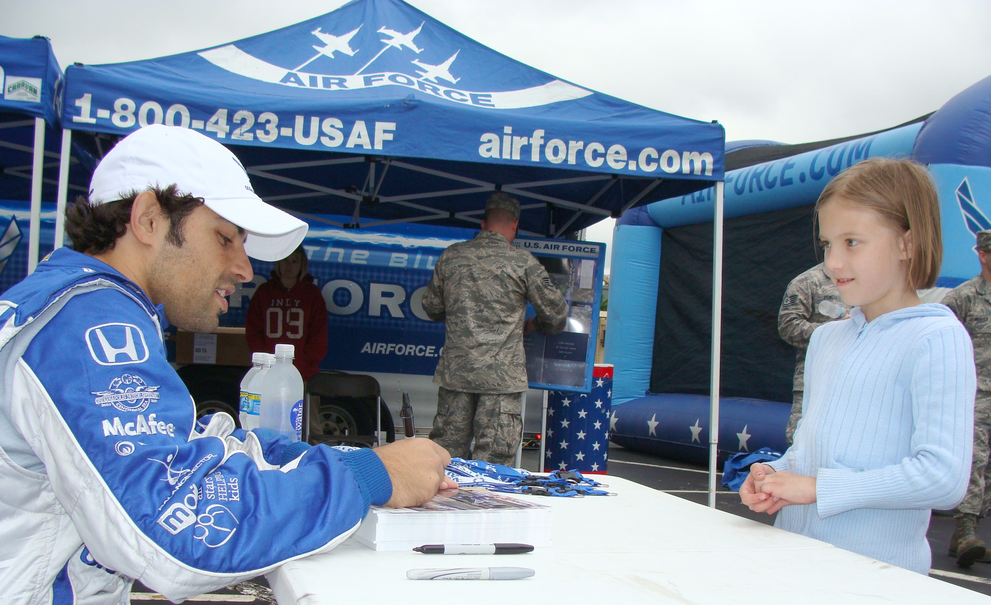 Luczo Dragon Racing No. 2 car driver Rafael Matos signs an autograph for a young race fan at the Air Force display May 16 at the Indianapolis Motor Speedway. The Indianapolis 500 May 24 features the debut of an Air Force-themed Indy car driven by Matos, who qualified 12th and starts from the fourth row. The speedway recognizes the contributions of military men and women annually as each of the services display equipment and static aircraft for race fans to see during Armed Forces Day weekend. (U.S. Air Force photo/Daniel Elkins) 