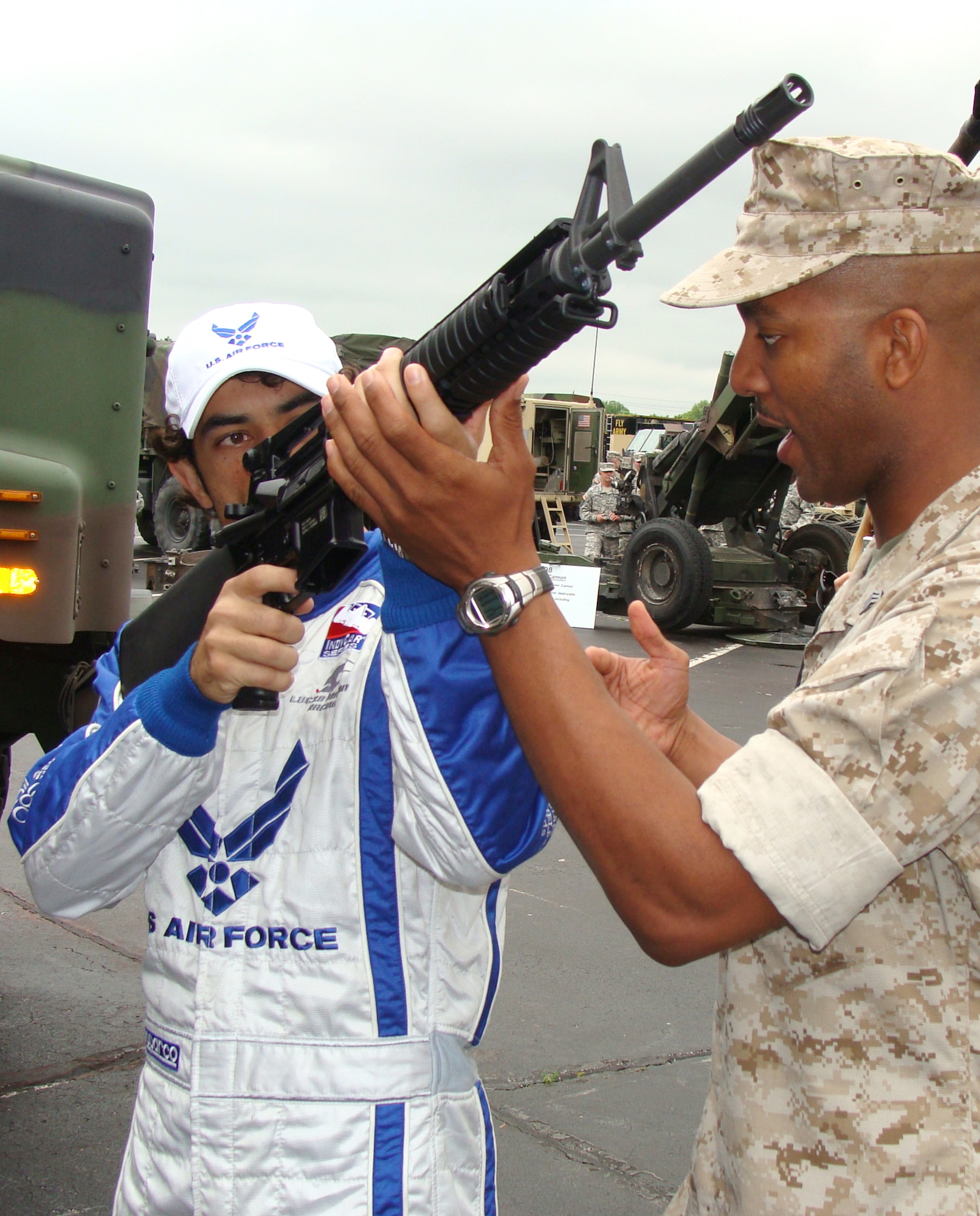 Luczo Dragon Racing No. 2 car driver Rafael Matos takes a few pointers from Indiana Marine Reservist Sgt. Gerrick Fallon May 16 at the Indianapolis Motor Speedway. Matos is driving the Air Force-themed Indy car in the Indianapolis 500 May 24 after qualifying 12th with the fastest time of five rookies in the field. The speedway recognizes the contributions of military men and women annually as each of the services display equipment and static aircraft for race fans to see during Armed Forces Day weekend. (U.S. Air Force photo/Daniel Elkins) 
