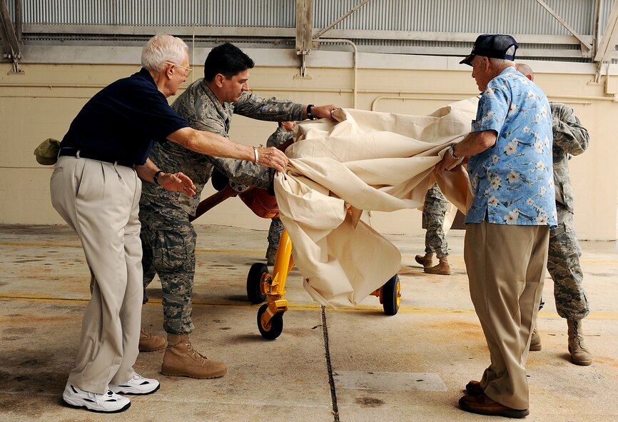 AVON PARK AIR FORCE RANGE, Fla. -- Retired Col. Roy Whitton, retired Capt. Louis Brough and Airmen from the 23rd Equipment Maintenance Squadron, Moody Air Force Base, Ga., reveal the newly restored Radio Plane OQ-19D (KD-2R3) Target Drone at Avon Park Air Force Range, Fla., May 18. The restoration project took a total of 8 months and more than 720 hours to complete. (U.S. Air Force photo by Airman 1st Class Joshua Green)
