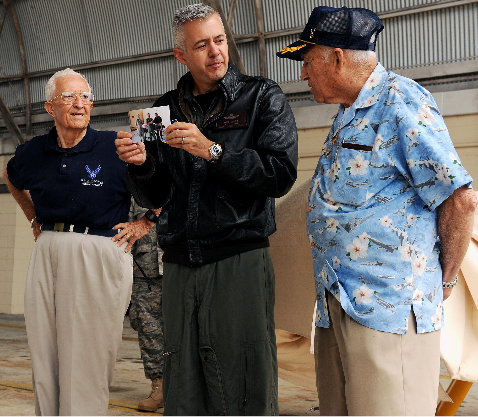 AVON PARK AIR FORCE RANGE, Fla. -- (Left to right) Retired Col. Roy Whitton, Col. Kenneth Todorov, 23rd Wing ommander, Moody Air Force Base, Ga., and retired Capt. Louis Brough, view photographs and speak about the history of the Radio Plane OQ-19D (KD-2R3) Target Drone before revealing its restored look at Avon Park Air Force Range, Fla., May 18. The drone was hit by a .50 caliber bullet through its tail end which caused it to crash. U.S. Air Force photo by Airman 1st Class Joshua Green) 
