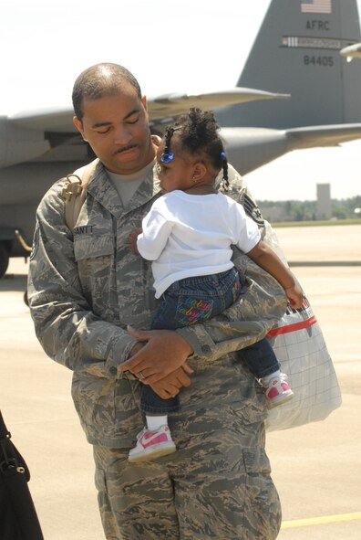 Staff Sgt. Elijah Gantt, 2nd Airlift Squadron, holds his daughter Brooke, 14 months, after returning to Pope Air Force Base, N.C. May 12 from a deployment to Southwest Asia. (U.S. Air Force Photo by Airman 1st Class Mindy Bloem)