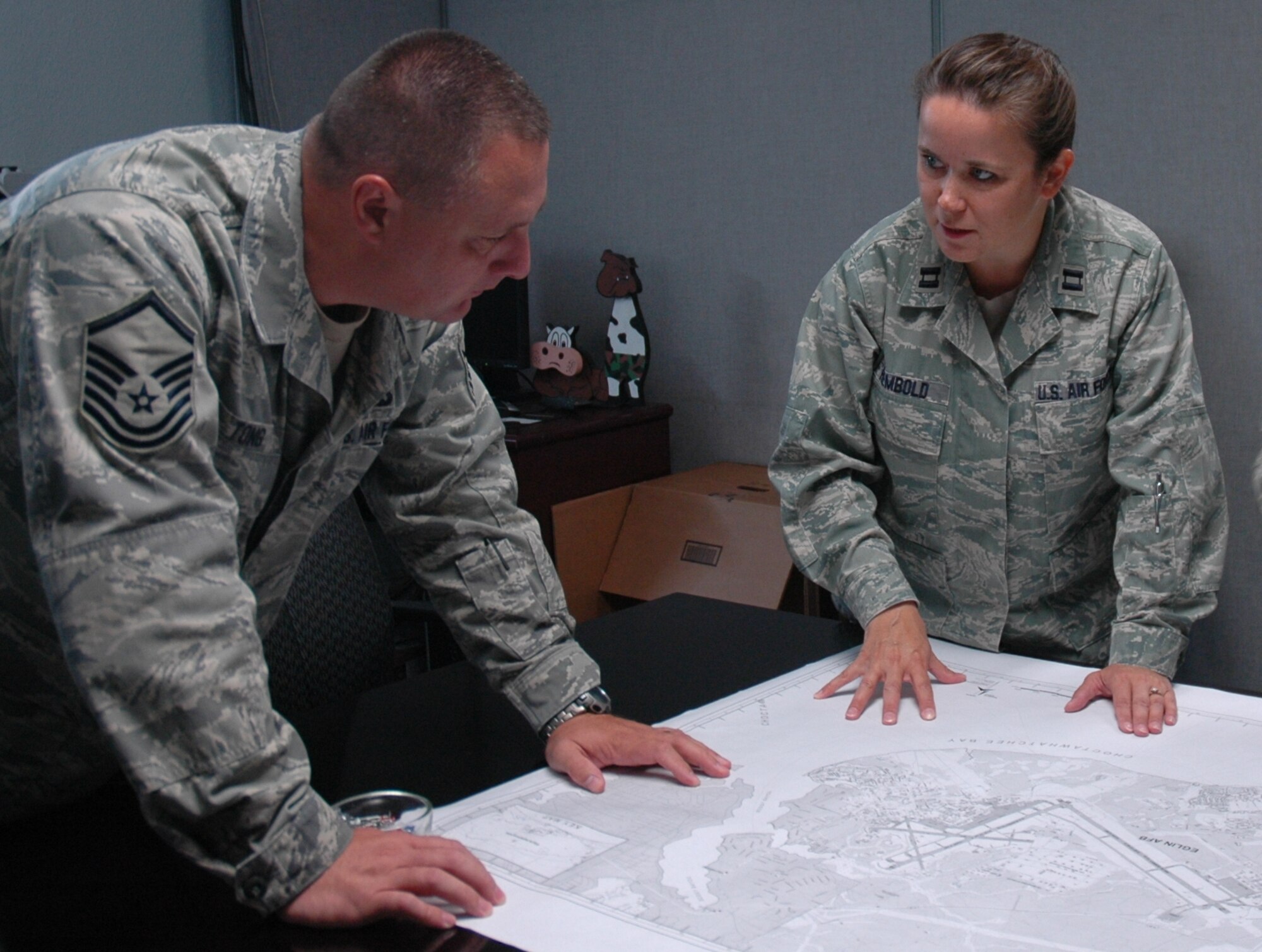 Capt. Stacie Rembold, right, 96th Communication Squadron infrastructure
flight commander, maps out a plan, with Master Sgt. Brian Tong, to provide
an emergency phone system for one of Eglin's running tracks. The captain was
recently awarded an Air Force leadership award from the D.C. Chapter of the
Armed Forces Communications and Electronics Association. (U.S. Air Force photo/Chrissy Cuttita)
