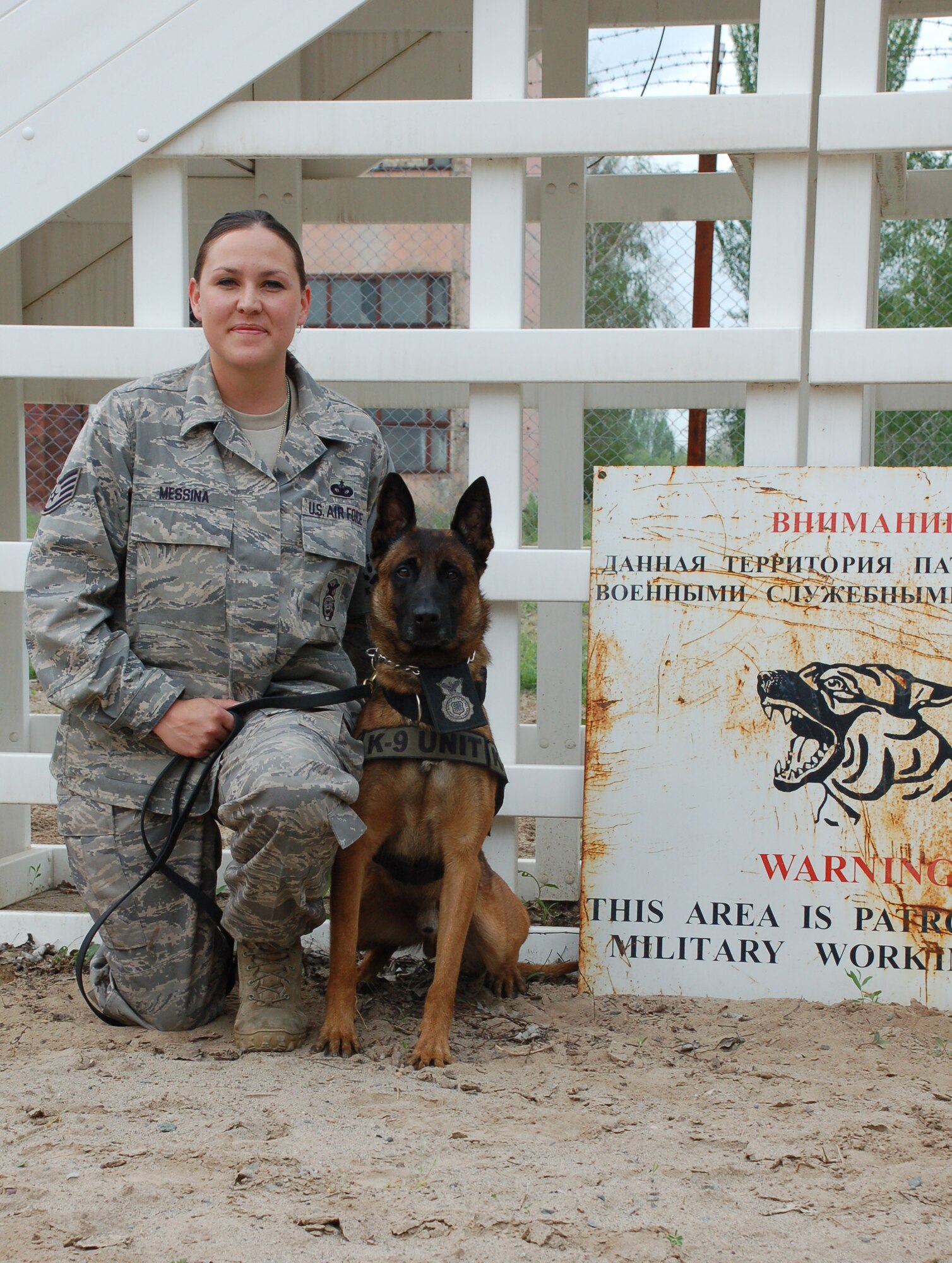 MANAS AIR BASE, Kyrgyzstan --  Staff Sgt. Teri Messina takes a moment from training to pose with her canine partner Rico here. Sergeant Messina and Rico are deployed here from the 30th Security Forces Squadron. (U.S. Air Force photo/Tech. Sgt. Phyllis Hanson)
