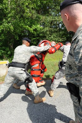 4th Security Forces Squadron members take control of a protester in a "Red Man" suit during a training exercise on Seymour Johnson Air Force Base, N.C., May 19, 2009. Staff Sgt. Brian Jackson (4th SFS) wore the suit during the protest exercise and became combative, allowing the Airmen to apply the use of force. The padded Red Man suit allows Airmen to more realistically practice baton striking techniques.  (U.S. Air Force photo by Airman 1st Class Gino Reyes)