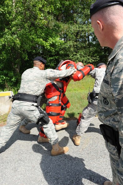 4th Security Forces Squadron members take control of a protester in a "Red Man" suit during a training exercise on Seymour Johnson Air Force Base, N.C., May 19, 2009. Staff Sgt. Brian Jackson (4th SFS) wore the suit during the protest exercise and became combative, allowing the Airmen to apply the use of force. The padded Red Man suit allows Airmen to more realistically practice baton striking techniques.  (U.S. Air Force photo by Airman 1st Class Gino Reyes)