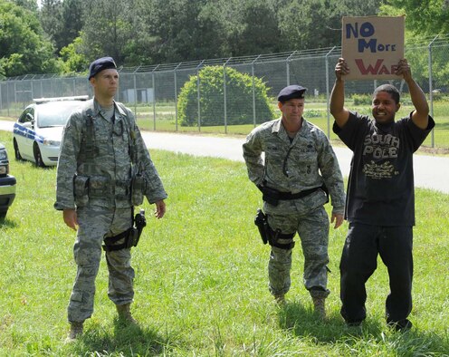 Technical Sgt. Ryan McLain and Airman 1st Class Daniel Rose, 4th Security Forces Squadron, screen a simulated protester away from their patrol vehicles during a training exercise on Seymour Johnson Air Force Base, N.C., May 19, 2009. Airmen from the 4th Logistics Readiness Squadron acted as protesters to help measure specific exercise objectives. (U.S. Air Force photo by Airman 1st Class Gino Reyes) 