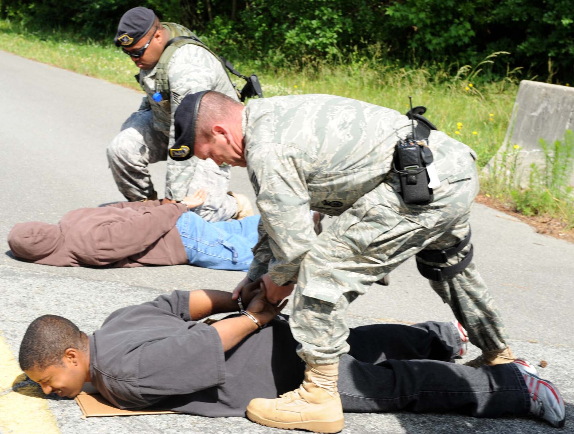 Technical Sgt. Ryan McLain and Staff Sgt. Michael Allen, 4th Security Forces Squadron, handcuff simulated protesters during a training exercise on Seymour Johnson Air Force Base, N.C., May 19, 2009. The 4th Security Forces Squadron exercises the 4th Fighter Wing Installation Security Plan to keep Airmen trained on proper procedures. (U.S. Air Force photo by Airman 1st Class Gino Reyes)