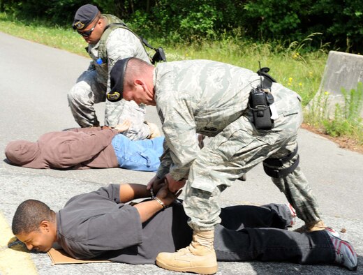 Technical Sgt. Ryan McLain and Staff Sgt. Michael Allen, 4th Security Forces Squadron, handcuff simulated protesters during a training exercise on Seymour Johnson Air Force Base, N.C., May 19, 2009. The 4th Security Forces Squadron exercises the 4th Fighter Wing Installation Security Plan to keep Airmen trained on proper procedures. (U.S. Air Force photo by Airman 1st Class Gino Reyes)