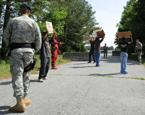 4th Security Forces Squadron members surround a simulated group of protesters to keep them from entering a restricted area during a training exercise on Seymour Johnson Air Force Base, N.C., May 19, 2009. The exercise evaluated Security Forces' response to a civil disturbance. (U.S. Air Force photo By Airman 1st Class Gino Reyes) 