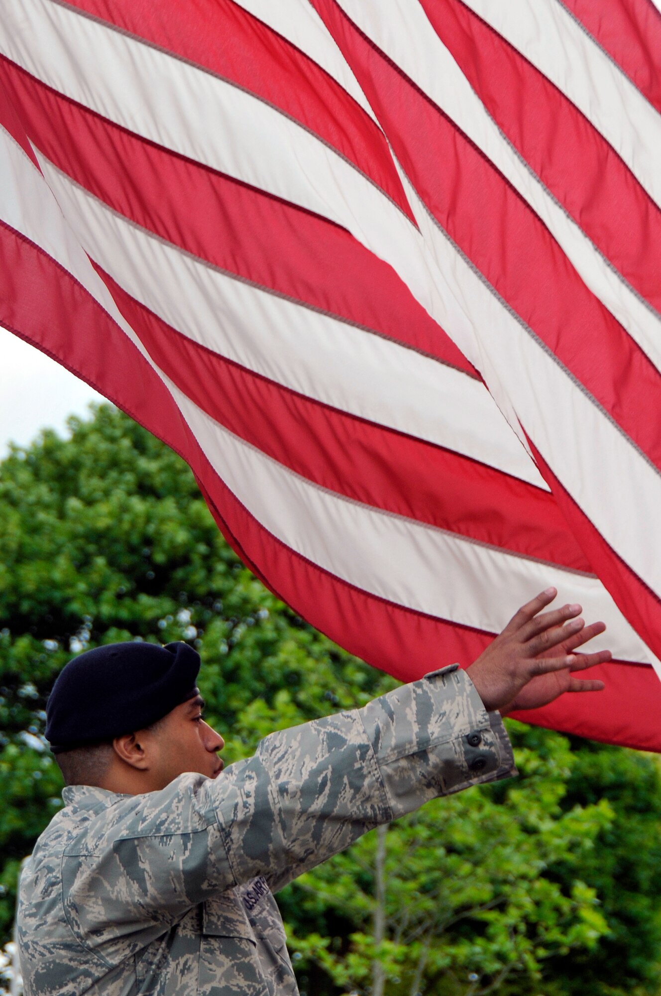 Airman 1st Class Misinimese Liulamaga, 48th Security Forces Squadron patrolman, takes hold of the American flag during a retreat ceremony May 15, 2009 at Royal Air Force Lakenheath, England. This retreat ceremony marked the end of the 2009 National Police Week events, held at both Royal Air Force Lakenheath and Mildenhall. (U.S. Air Force photo by Airman 1st Class Perry Aston)