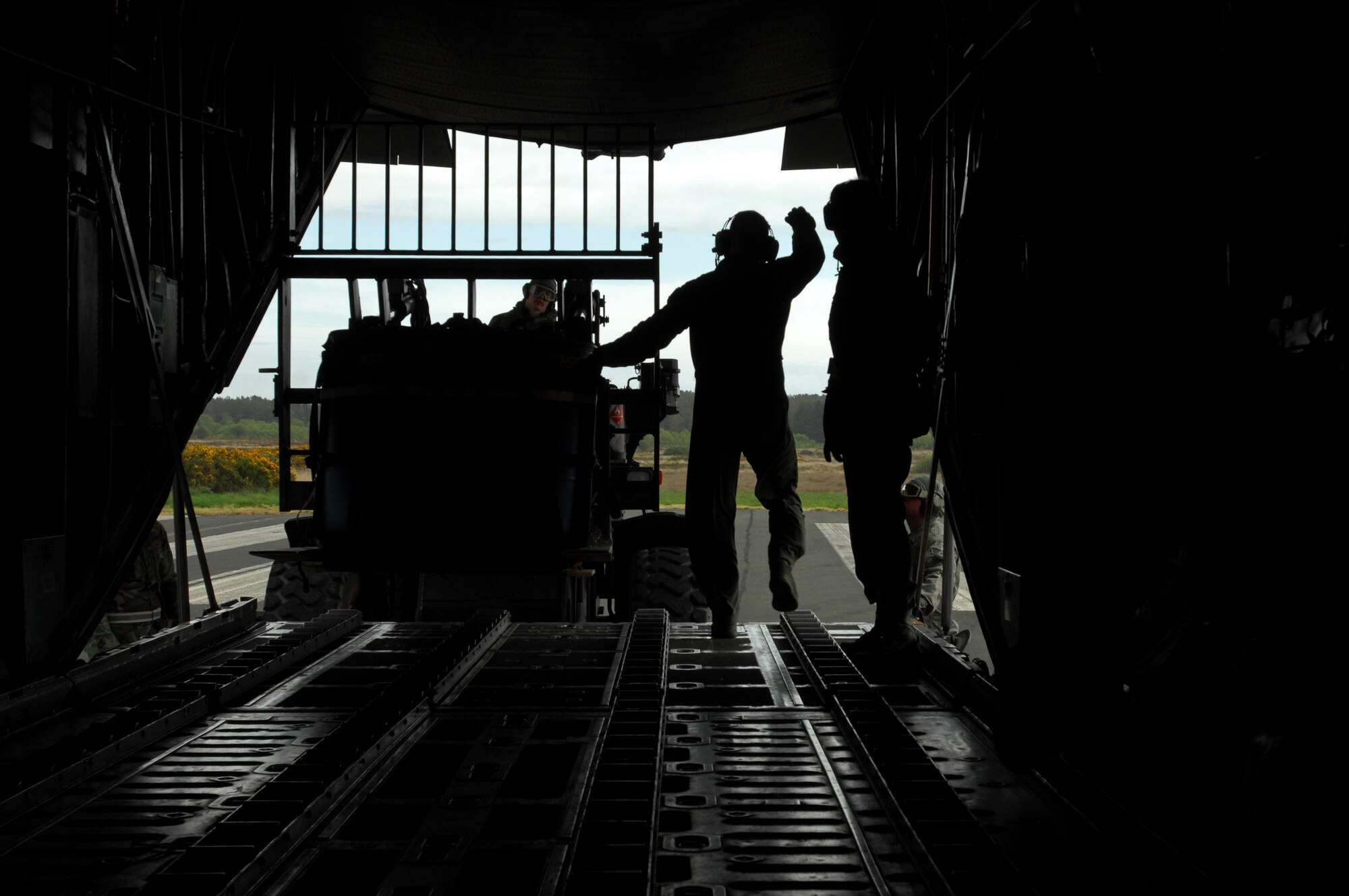 United States Air Force Staff Sgt. Matt Lafever, 37th Airlift Squadron performs an engines running on load by guiding a fork lift with cargo into the back of a C-130 Hercules during an Operational Readiness Exercise, May 19, 2009, West Freugh Airfield, Scotland. (U.S. Air Force photo by Senior Airman Kenny Holston)
