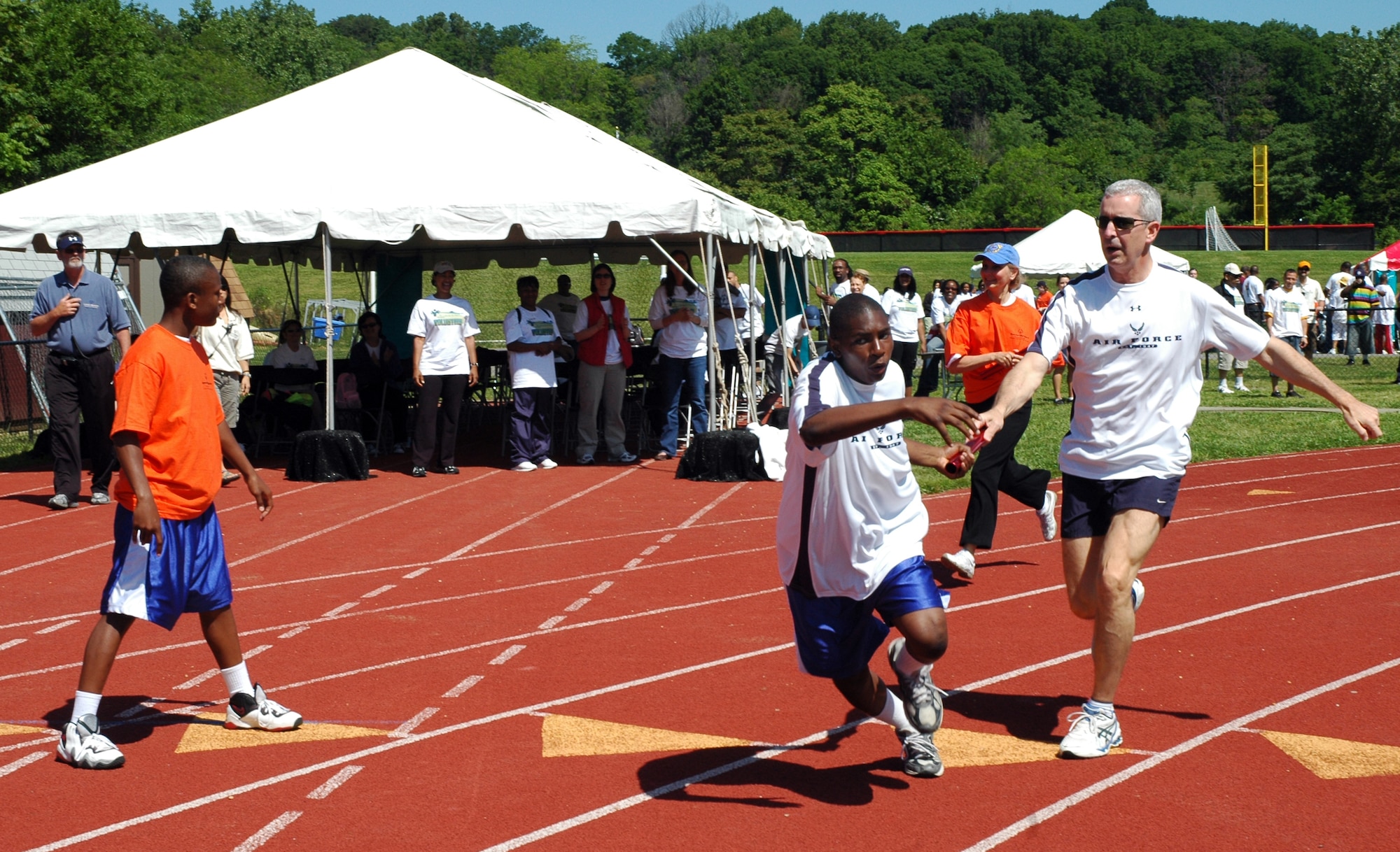 Col. Jon A. Roop, 11th Wing commander, passes a baton to Isaiah Waford during a 4x4 100-meter relay May 20 at the 2009 Special Olympics D.C. Summer Games at the Catholic University of America in Washington, D.C. (U.S. Air Force photo by Senior Airman R. Michael Longoria)