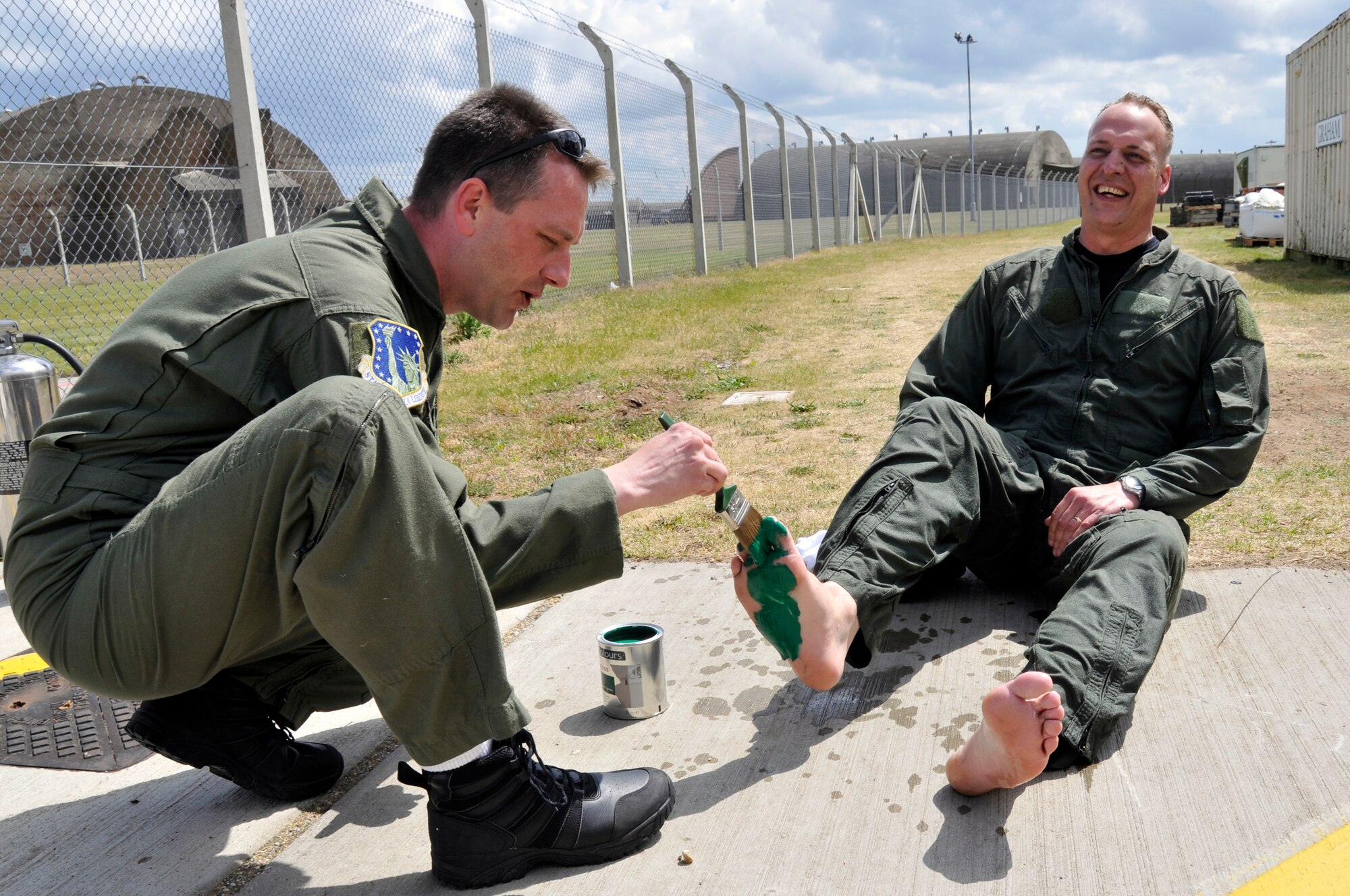 Master Sgt. Kevin Marlatt paints Master Sgt. Darren Bradley's feet green May 21, 2009 at Royal Air Force Lakenheath, England in celebration of Sergeant Bradley's completion of 5,000 hours in a HH-60G Pave Hawk. Sergeant Bradleys green feet will be placed in the 56th Rescue Squadron. (U.S. Air Force photo by Airman 1st Class Perry Aston)