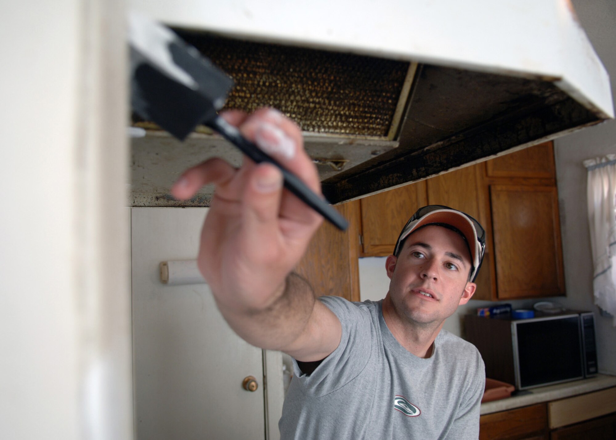 Airman Donnie Kukuk, 49th Force Support Squadron at Holloman Air Force Base, N.M., paints Mrs. Elma Smith?s kitchen during the United Way Day of Caring event held in Alamogordo, N.M., May 7. Teams of volunteers collaborated to restore homes. (U.S. Air Force photo/Airman 1st Class Veronica Stamps)