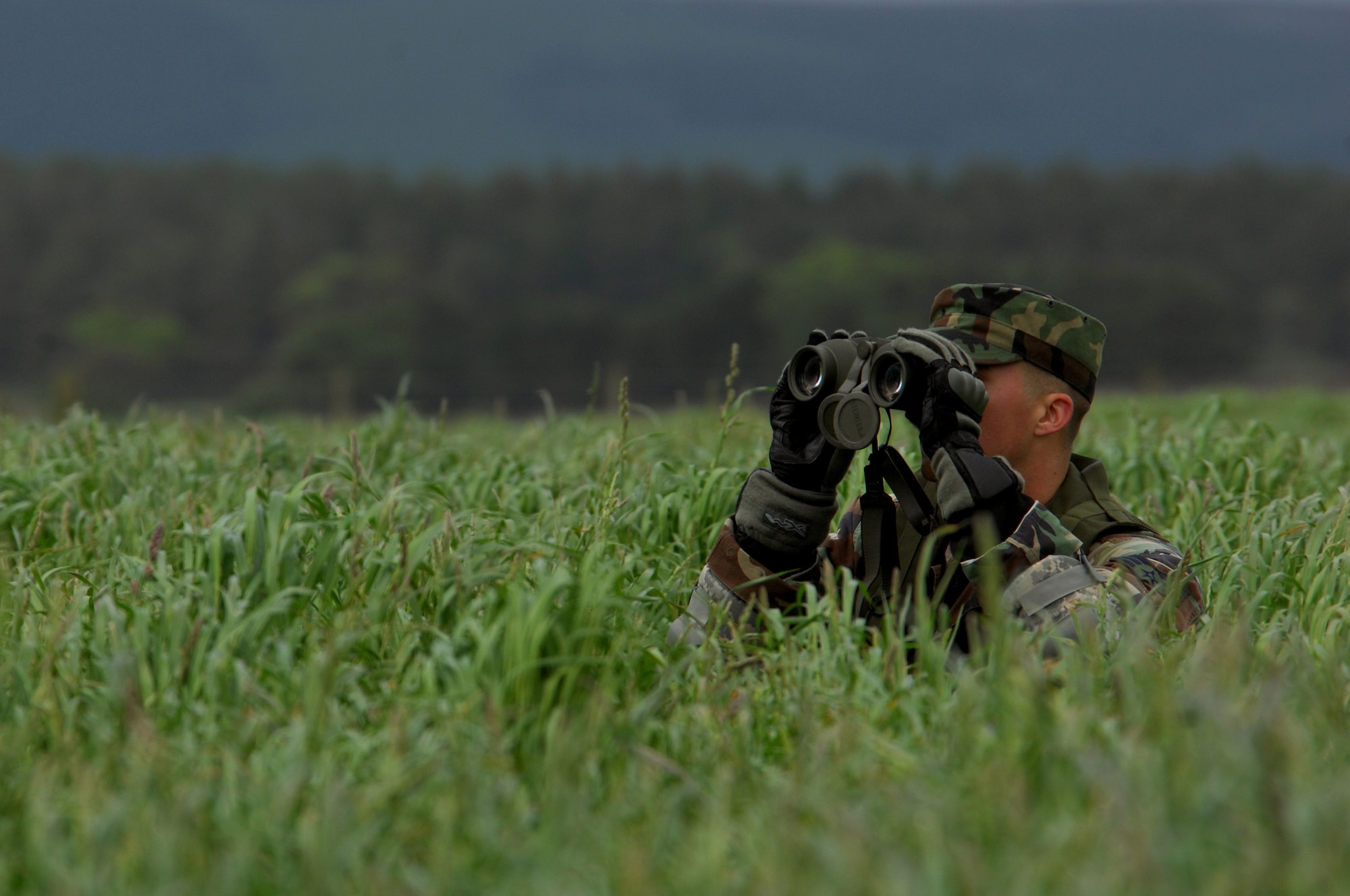 United States Air Force Senior Airman Nick Hurst, 786th Security Forces Squadron patrolman, peers across an airfield while waiting for the rest of his team to arrive in order to perform an airfield assessment during an Operational Readiness Exercise, May 18, 2009, West Freugh Airfield, Scotland. (U.S. Air Force photo by Senior Airman Kenny Holston)