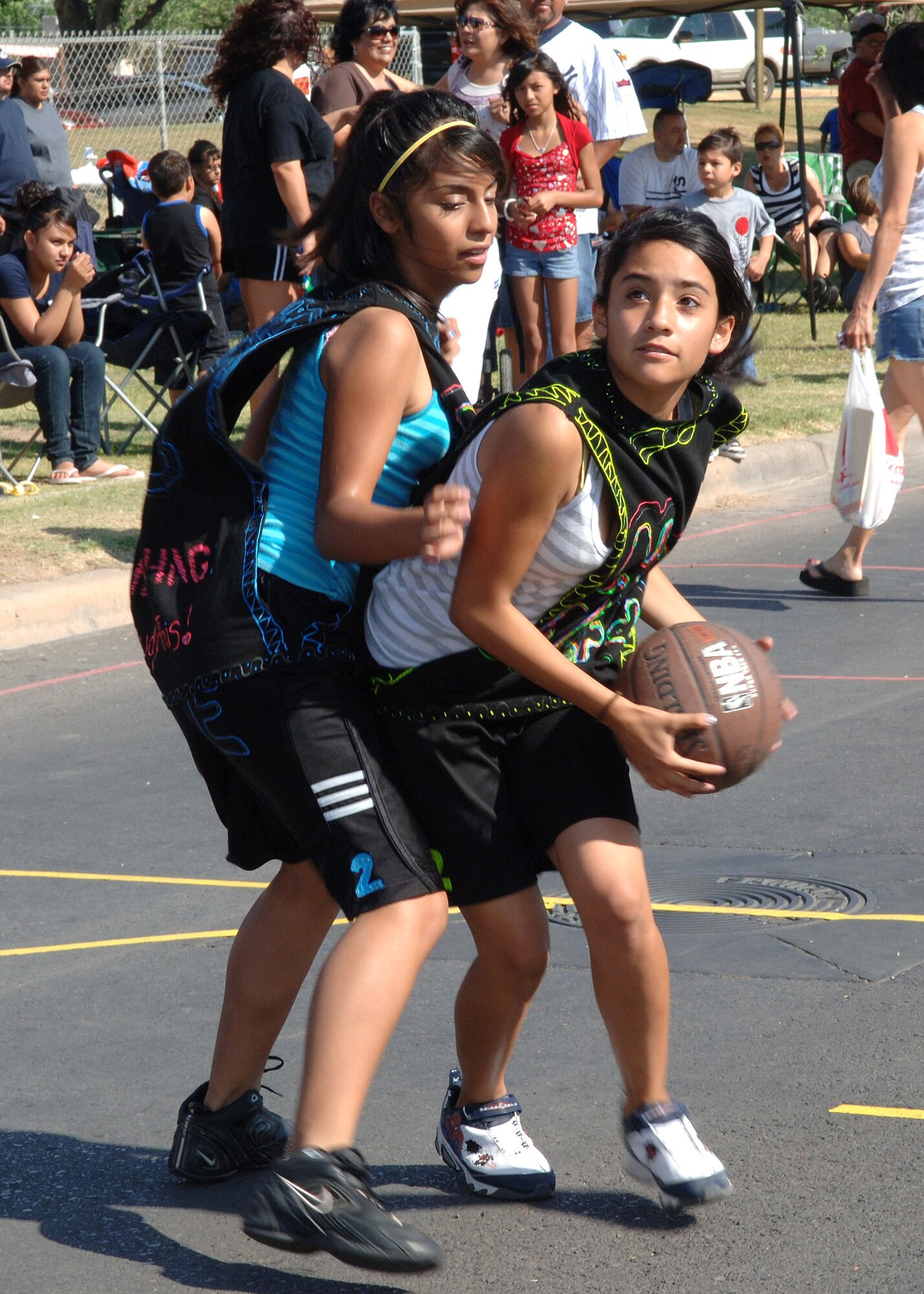 Nerd Herd teammates Darling Provencio and Paola Maldonado from Tularosa, N.M., practice before the real game during Saturday in the Park/Armed Forces Day Celebration at Washington Park in Alamogordo, N.M, May 16. The Gus Macker event was opened to basketball teams throughout New Mexico of all ages to compete. (U.S. Air Force photo/ Ariman 1st Class Veronica Stamps)