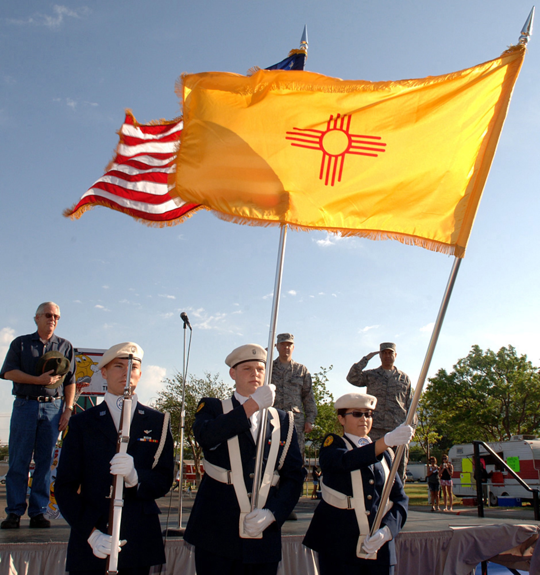 The Alamogordo Junior Reserve Officers' Training Corps (ROTC) present the colors at the opening ceremony for Saturday in the Park/Armed Forces Day Celebration at Washington Park in Alamogordo, N.M., May 15. Command Chief Master Sgt. Jeffrey Cui, 49th Fighter Wing and Father Mathew Glaros, Holloman Chapel, present a speech and a prayer before the flyover of two F-22A Raptor.s (U.S. Air Force photo/Airman 1st Class Veronica Stamps)