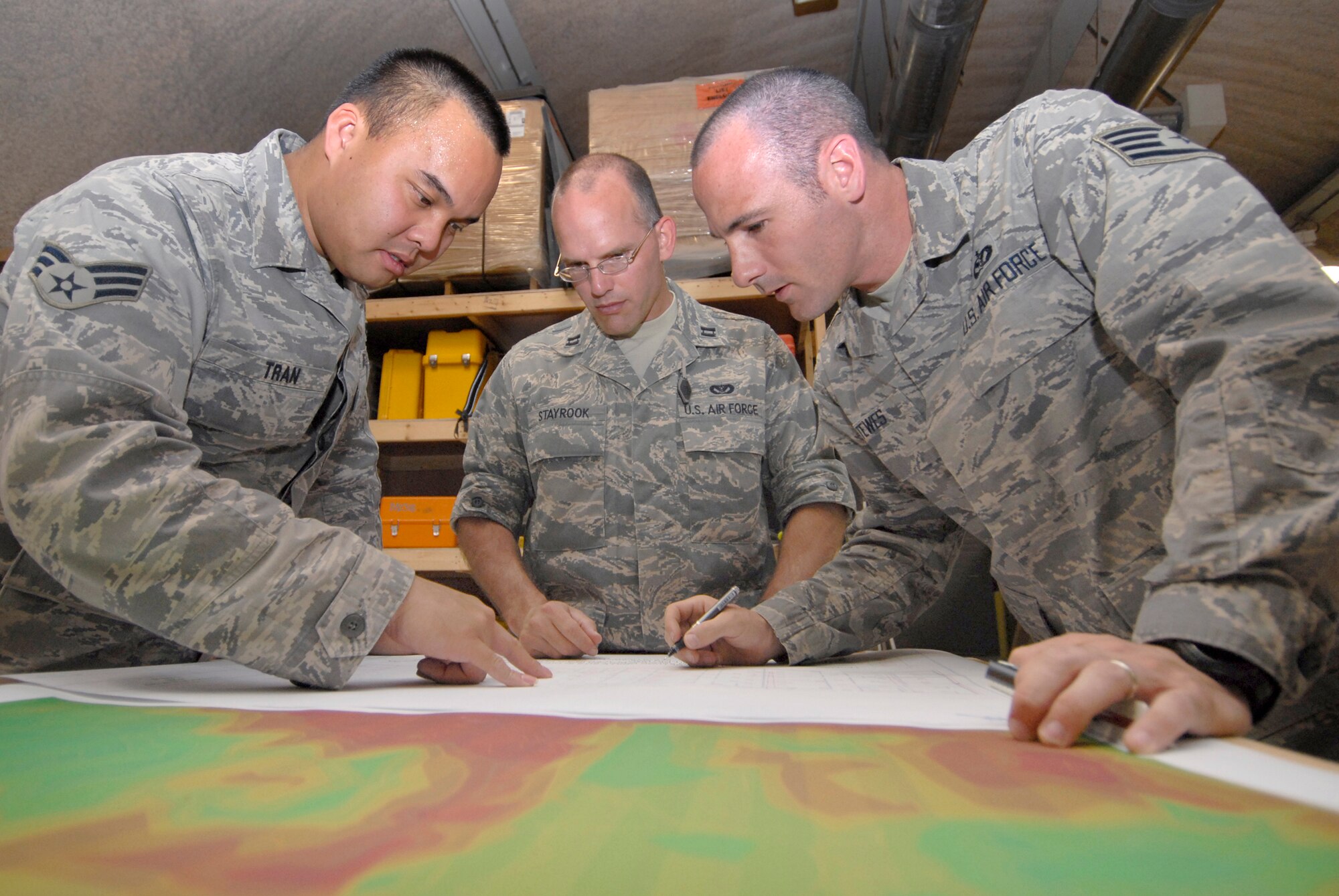 Senior Airman Tien Tran and Staff Sgt. Michael Tewes, 1st Expeditionary RED HORSE group (ERHG) engineer technicians, work with Captain Michael Stayrook, 1st ERHG design cell supervisor, to plan the layout for a Heating, Ventilating and Air Conditioning (HVAC) system, May 20, 2009, at an undisclosed location in Southwest Asia.  The HVAC plan is for an expansion to a hospital in support of Operation Iraqi Freedom.  Airman Tran hails from Fairfax, Va. and is deployed from Malmstrom Air Force Base, Mont.  Capt. Stayrook hails from Lobelville, Tenn. and is deployed from Elmendorf Air Force Base, Ala.    Sergeant Tewes hails from Goldsboro, N.C. and is deployed from Hickam Air Force Base, Hawaii.  All are deployed in support of Operations Iraqi and Enduring Freedom and Combined Joint Task Force - Horn of Africa.  (U.S. Air Force photo/Senior Airman Andrew Satran/released)