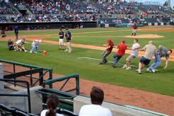 An Air Force team, left, and a Coast Guard team, right, battle it out in a game of tug-of-war during the Charleston RiverDogs baseball game at Joseph P. Riley Jr., Park May 20. The Air Force's winning streak came to an end when the Coast Guard pulled them across the line. The RiverDogs Committee held their first of two military appreciation nights at "The Joe" in support of Military Appreciation Month. (U.S. Air Force photo/Staff Sgt. Marie Cassetty)