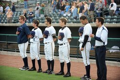 Members of the Charleston RiverDogs stand and face the flag during the national anthem prior to the start of the Charleston RiverDogs baseball game at Joseph P. Riley Jr., Park May 20. The RiverDogs are a Class-A affiliate of the New York Yankees and have celebrated more than ten years of baseball action in "The Joe."  (U.S. Air Force photo/Staff Sgt. Marie Cassetty)