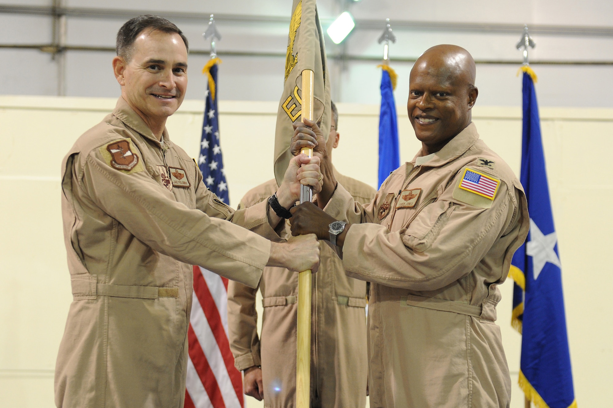 Brig. Gen. H.D. Polumbo Jr., 380th Air Expeditionary Wing, commander, passes the flag of the 380th Expeditionary Operations Group Col. Soren Jones as he takes command, May 18 at an undisclosed location in Southwest Asia. Colonel Jones comes from the Air Combat command headquarters at Langley AFB, Va. to lead the 380th EOG. (U.S. Air Force photo by Senior Airman Brian J. Ellis) (Released)