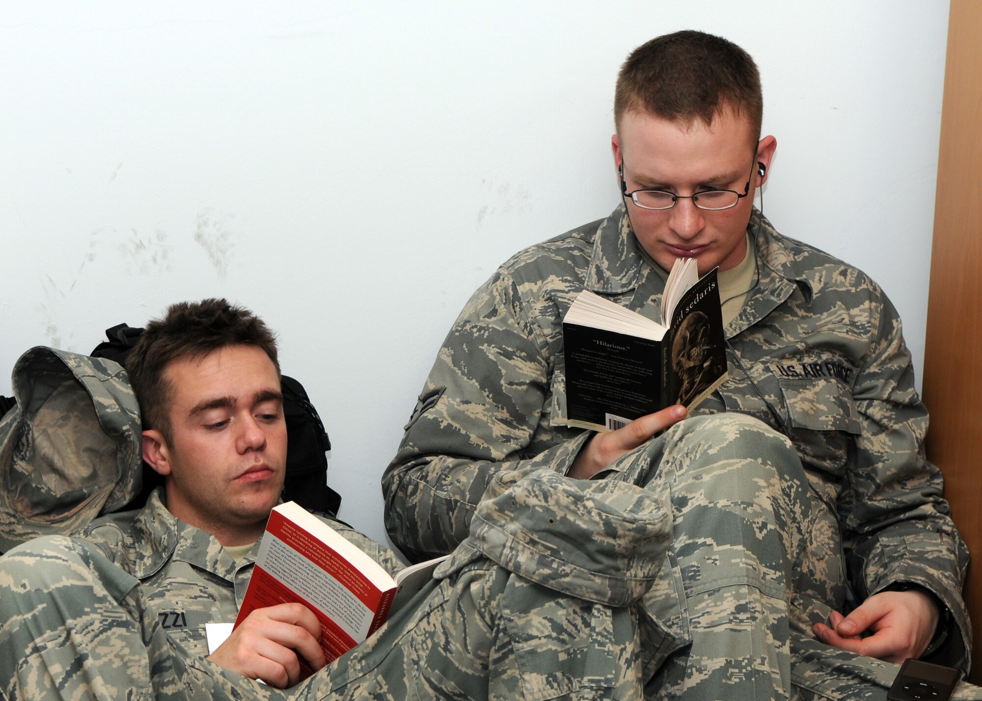 SPANGDAHLEM AIR BASE, Germany -- Senior Airman Dalton Polizzi and Airman 1st Class Patrick Morphy, both from the 52nd Operation Support Squadron, found a quiet corner to enjoy their books May 19, 2009.   Sabers found many ways to pass the time waiting for their flight to various locations downrange to support overseas contingency operations.  (U.S. Air Force photo by Staff Sgt. Heather M. Norris)