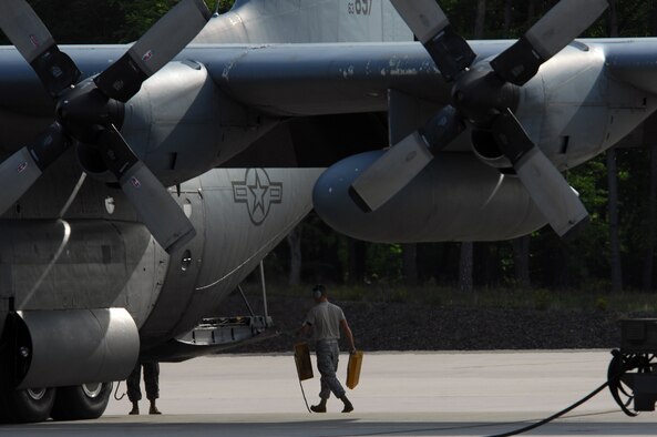 A United States Air Force maintainer with the 86th Aircraft Maintenance Squadron pulls the chalks from the tires of a C-130 Hercules before takeoff, May 8, 2009, Ramstein Air Base, Germany. (U.S. Air Force photo by Senior Airman Kenny Holston)